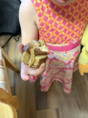 Baby holding a homemade french toast muffin cup.